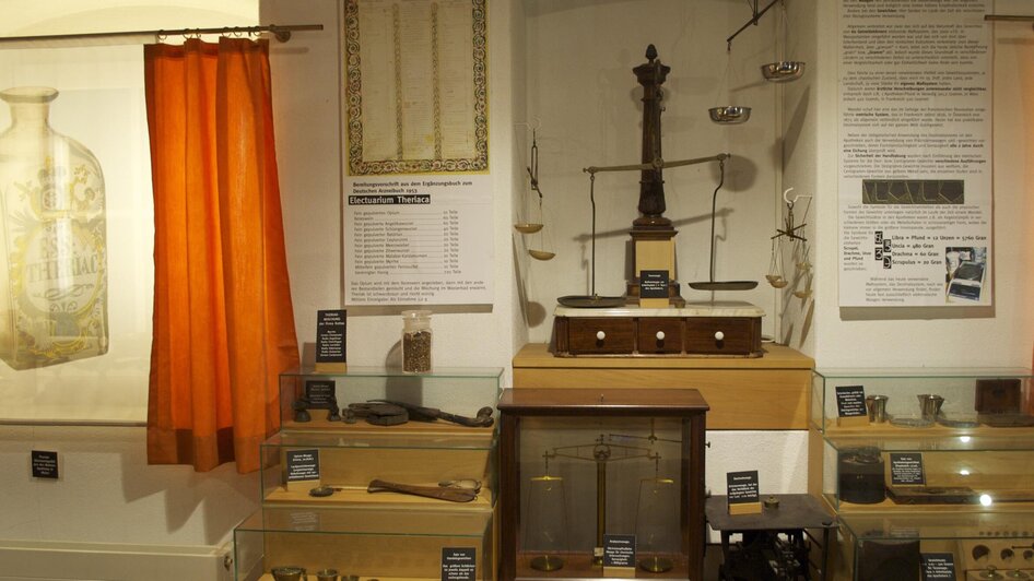 Einblick in das Theriakmuseum mit historischen Vitrinen und Informationswänden.