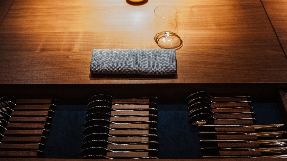 Eleganter Tisch mit einer goldenen Birne als Dekoration und Gläsern in einem Restaurant.