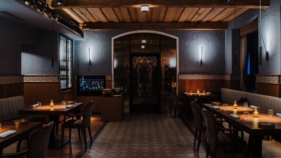 Elegante Restaurantansicht mit gedämpfter Beleuchtung und stilvollen Möbeln.