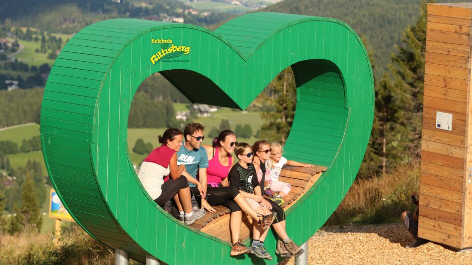 Grüne Herzbank am Rittisberg | © Erlebnis Rittisberg Familienfoto im grünen Herz. | © Erlebnis Rittisberg